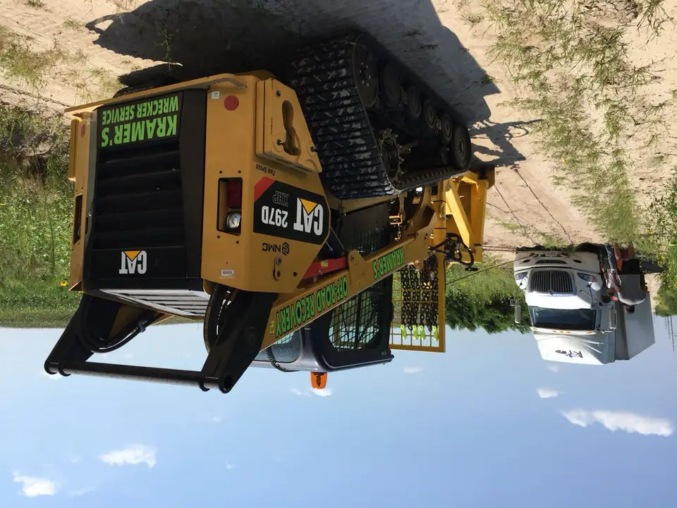 Skid steer anchoring a winch out of a stuck semi
